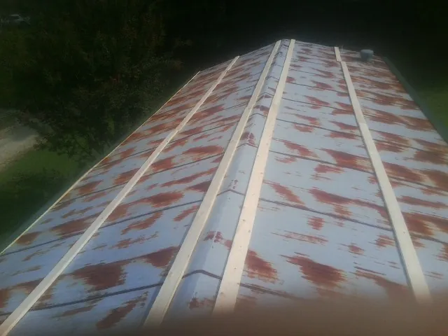 Rusted metal roof panels with new wood purlins before replacement — Storm Damage Roof Repair in Saint Henry by Roofing Brothers