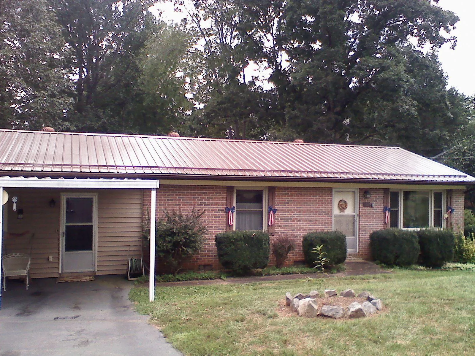 Bronze metal roof and carport on a brick ranch home — Roof Repair work by our crew in Saint Henry